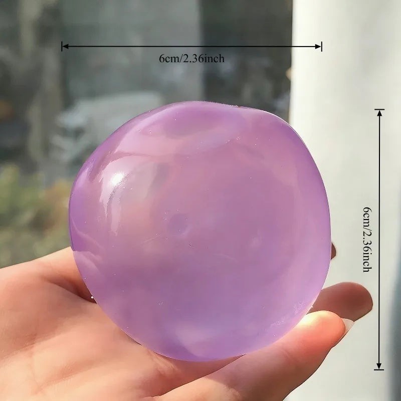 A Coconut Squishy ball, about 6 cm across, held in an open hand for scale